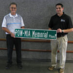 Jeff Strickland (left) and Mike Cassata hold the first POW-MIA Memorial parkway Sign