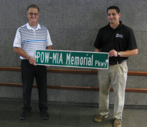 Jeff Strickland (left) and Mike Cassata hold the first POW-MIA Memorial parkway Sign