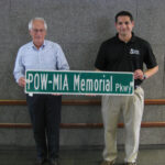 Pat Geer (left) and Mike Cassata hold the first POW-MIA Memorial parkway Sign